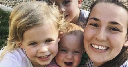 au pair med tre små barn i famnen