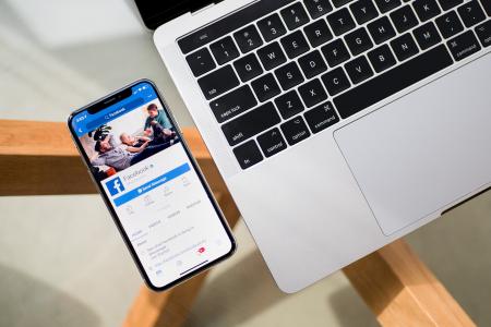 Smartphone och bärbar dator med Facebook-app